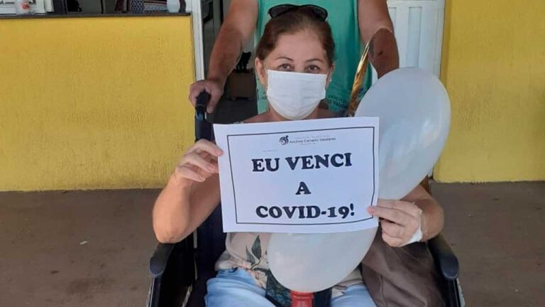 Paciente segurando placa que venceu a Covid-19