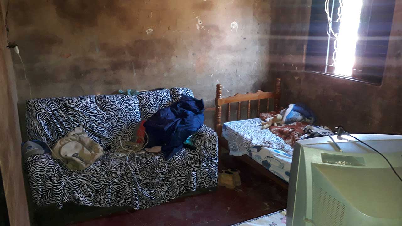 Pequena sala de convivência com sofá e cama