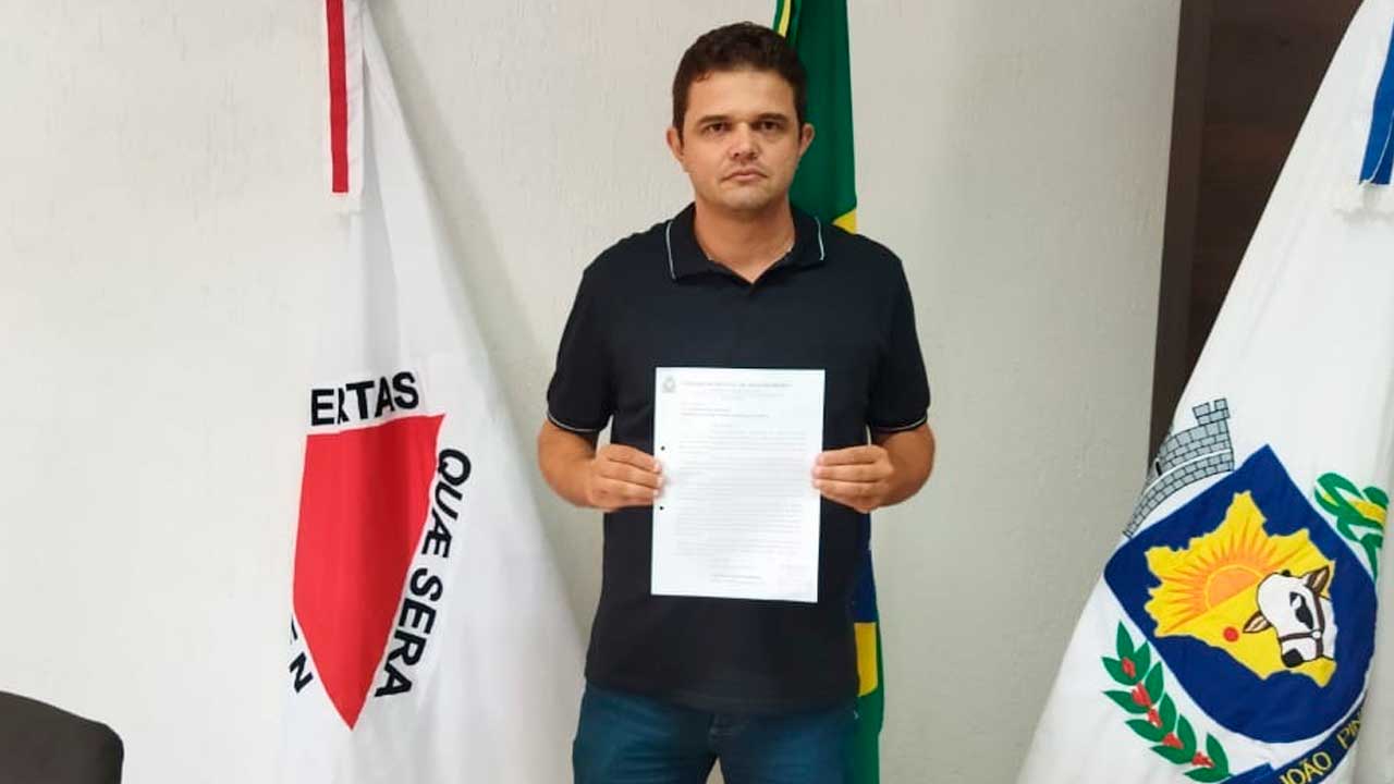 Vereador Cabo Vieira segurando projeto de lei de sua autoria que visa cassar alvará de postos condenados em segunda instância por prática de cartel