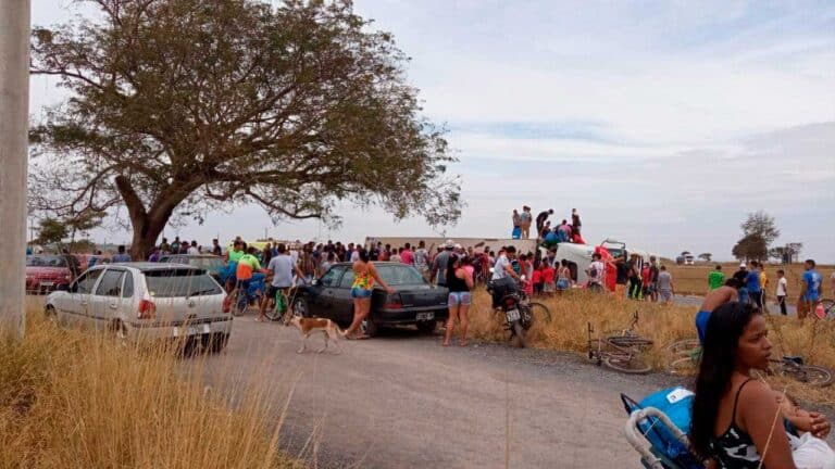 Pessoas em cima da carreta abrindo outra porta para facilitar o saque da carga