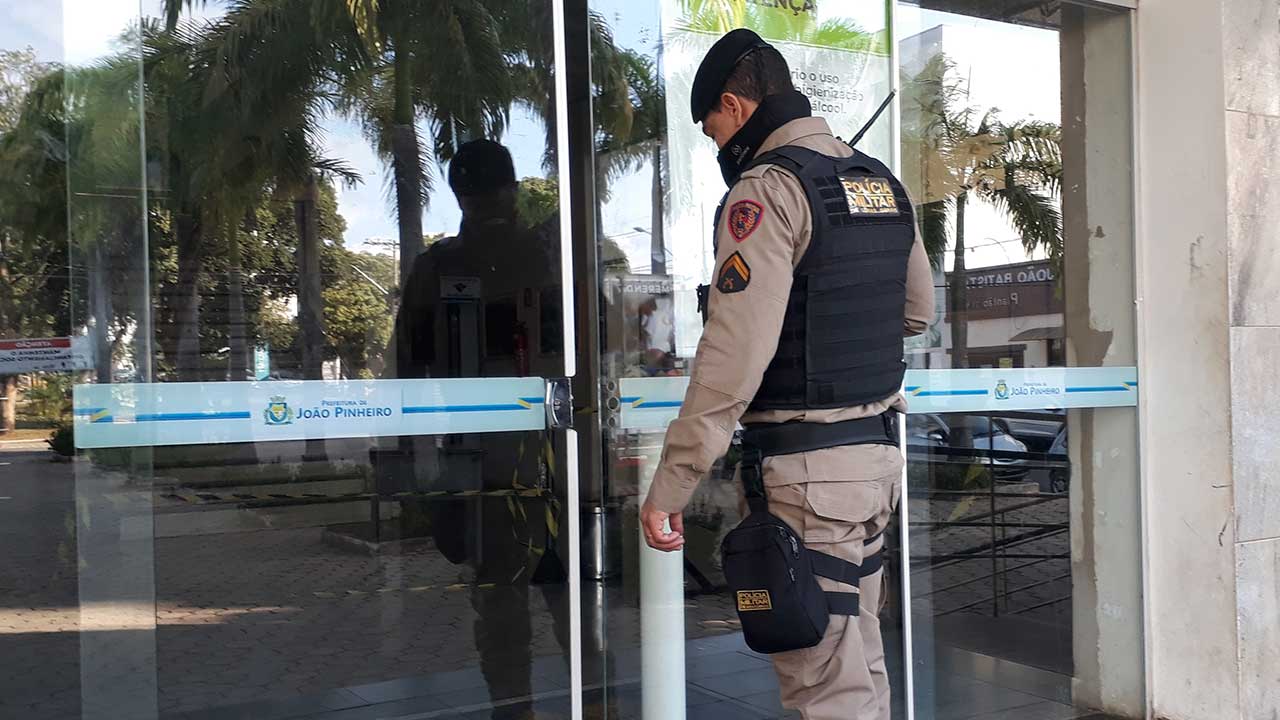 Policial Militar olhando porta arrombada por criminoso