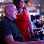 elderly couple gambling on slot machine in casino