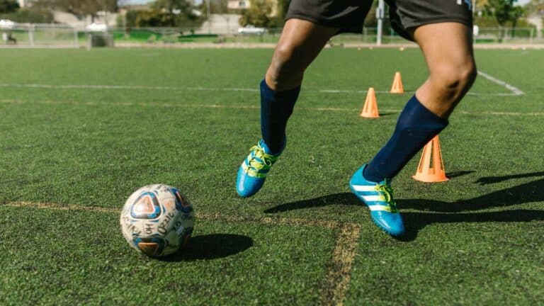 feet of soccer player tread on soccer ball for kick-off in the stadium