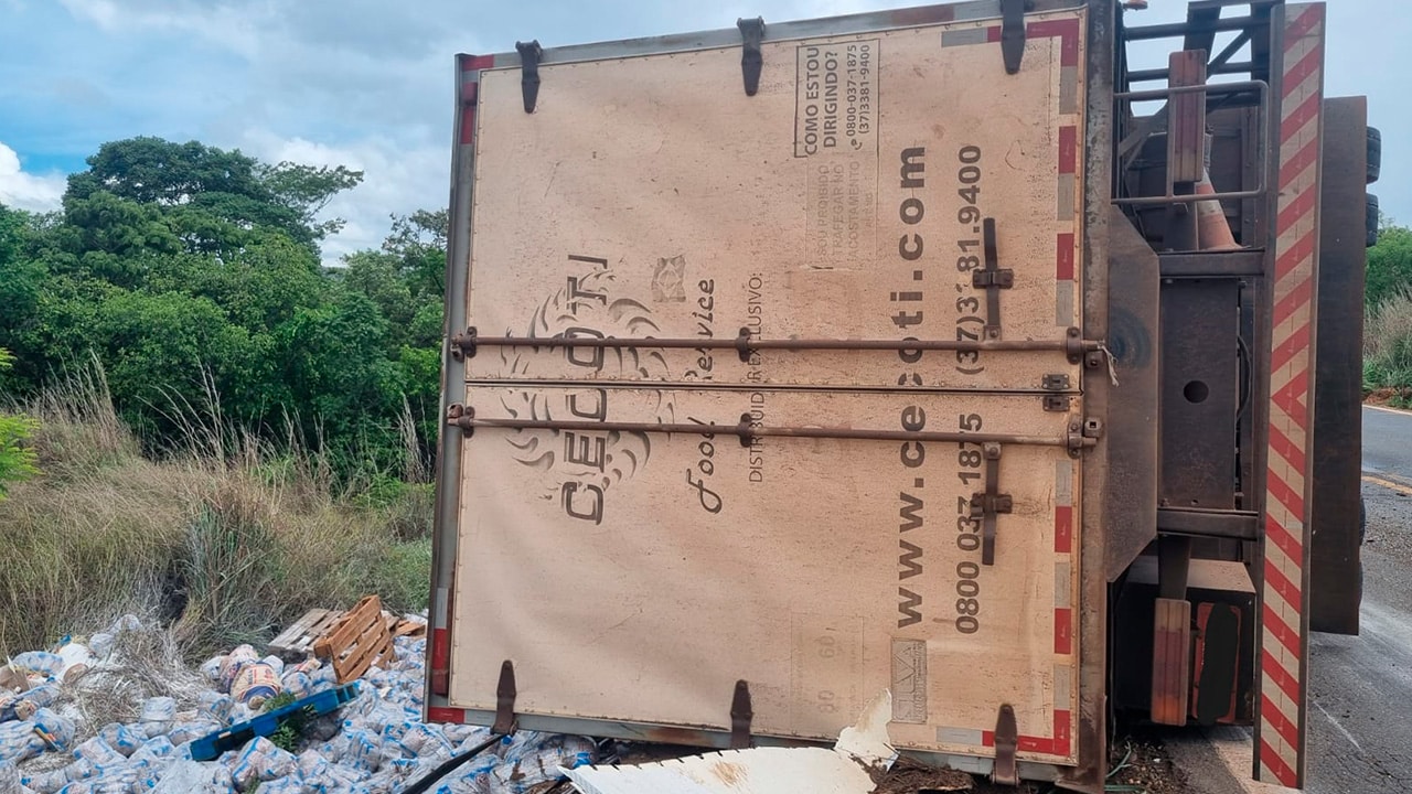 Carga de 11 toneladas de feijão fica espalhada na MG-410 após caminhão tombar em curva